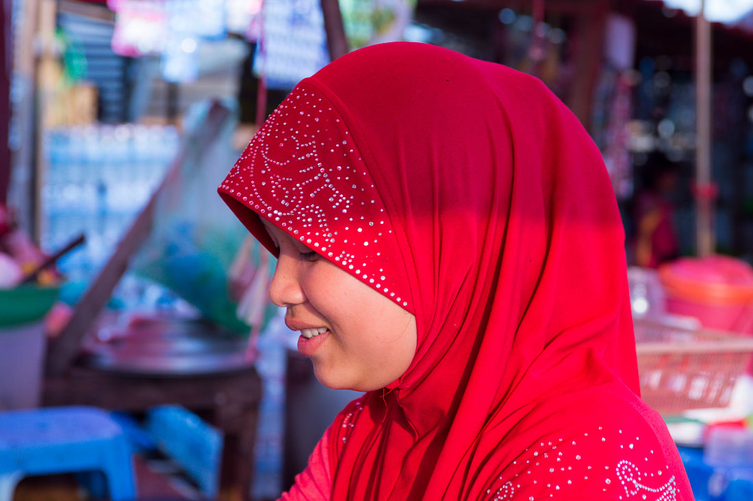 A young and beautiful Cham Muslim female butcher, wearing her hijab and selling beef meat at the Sen Monorom market, Mondulkiri province. Kingdom of Cambodia, Indochina, South East Asia