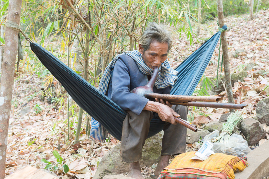 An old man from the ethnic group of the Bunong people playing an homemade  traditional musical instrument. Sen Monorom, Mondukiri province, Kingdom of Cambodia, Indochina, South East Asia