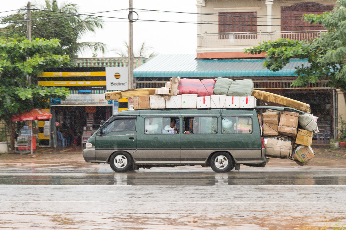 Mercedes minivan made in Korea loaded with passengers and a lot of merchandise; Phnom Penh, Kingdom of Cambodia, Indochina, South East Asia.