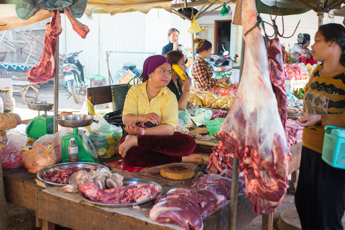 A young and beautiful Cham Muslim female butcher selling beef meat at the Ban Lung market, Ratanakiri province. Kingdom of Cambodia, Indochina, South East Asia