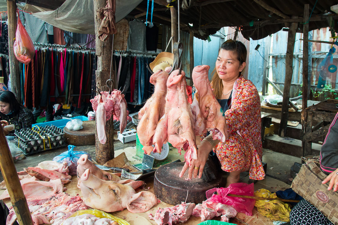 Selling pig heads at the market in Siem Reap; Kingdom of Cambodia, Indochina, South East Asia.