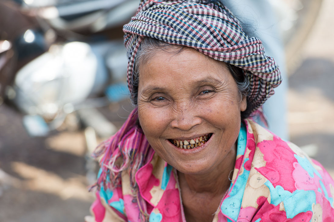 Woman smiling at the Stung Treng market, Stung Treng province, showing left over of the blackned teeth tradition. Kingdom of Cambodia, Indochina, South East Asia