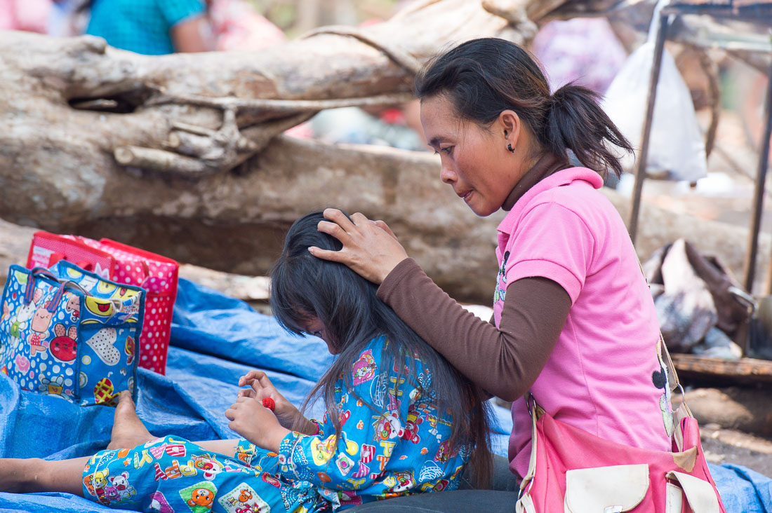 Woman busy in removing pets from the hair of her daughter, Sen Monorom, Mondulkiri province. Kingdom of Cambodia, Indochina, South East Asia.