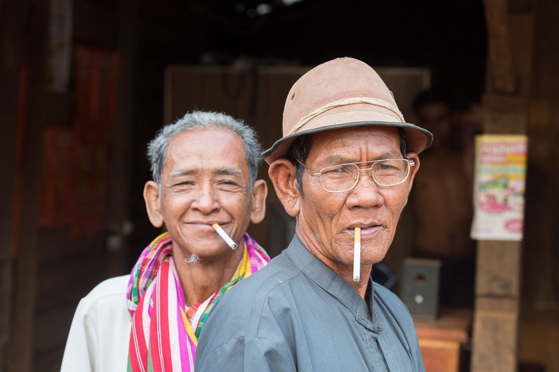 Two men smoking a cigarette in early morning, Sra Yong, Siem Reap province. Kingdom of Cambodia, Indochina, South East Asia