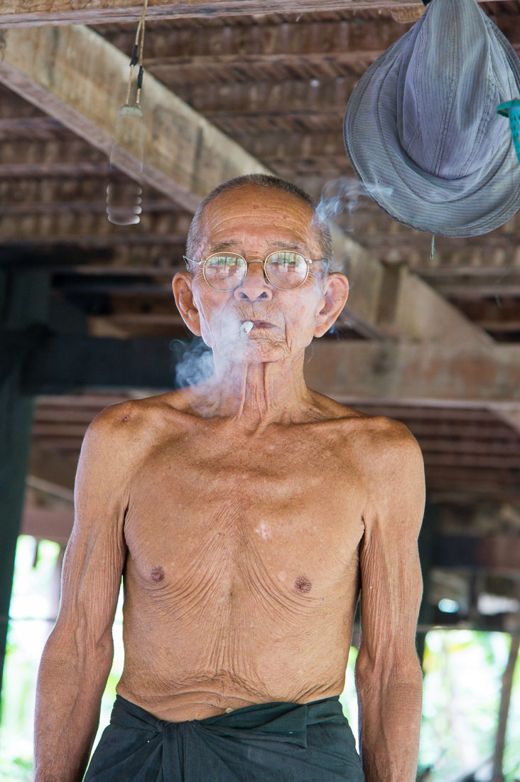 This old man is 90, very happy, he smokes 'only' 5 cigarettes a day and he is in extremely good health. Kompong Chan, Kingdom of Cambodia, Indochina, South East Asia.