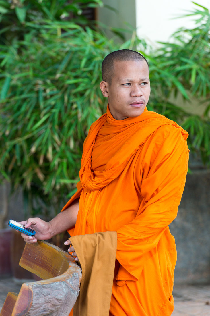 A Buddhist monk with his cellular phone, Ounalom pagoda. Phnom Penh, Kingdom of Cambodia, Indochina, South East Asia