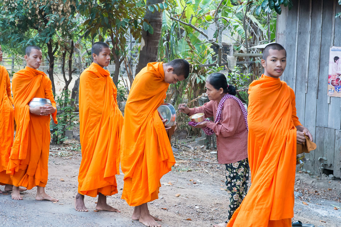 Young buddhist monks collecting food alms, Kratie, Kompong Chan province. Kingdom of Cambodia, Indochina, South East Asia