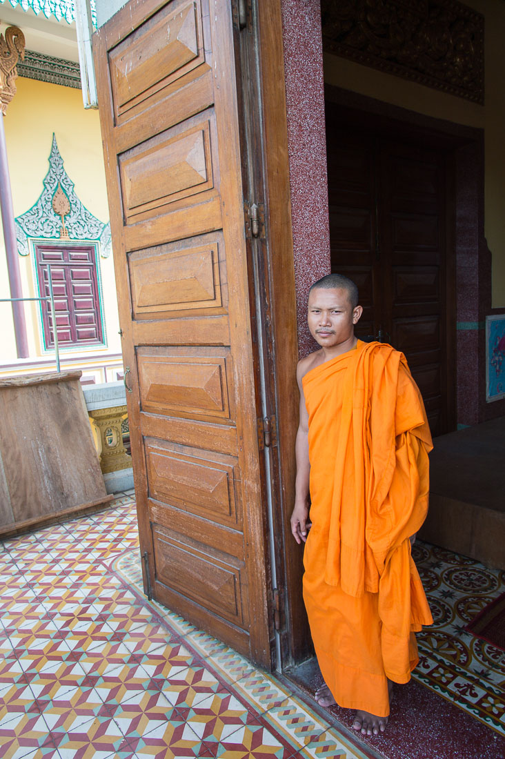 Buddhist monk at the entrance of the Wat Ounalom. Phnom Penh, Kingdom of Cambodia, Indochina, South East Asia.