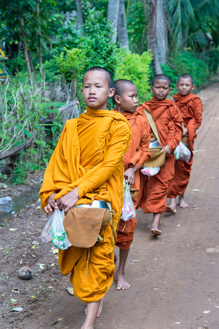 Younk Buddhist monks collecting food offers from people, Kompong Chan province. Kingdom of Cambodia, Indochina, South East Asia