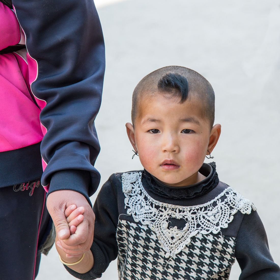 Little girl from the Yi ethnic minority people, with a funny air cut, at the Jia Yin village market, Hong He county, Yunnan Province, China, Asia. Nikon D4, 24-120mm, f/4.0, VR