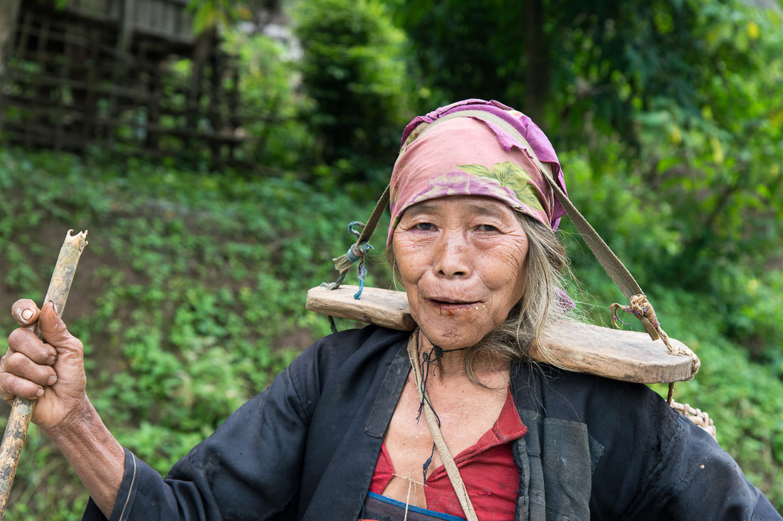 Old woman from the Akha people ethnic minority, with her bamboo back pack, Luang Namtha Province. Lao PDR, Indochina, South East Asia