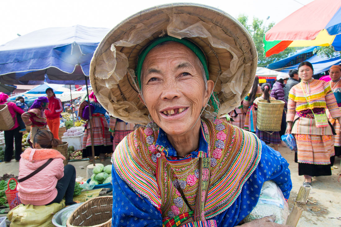 An old woman from the Flower Hmong people ethnic minority wearing her bamboo hat and showing a big smile, Bac Ha market, Lao Cai Province, Viet Nam, Indochina, South East Asia