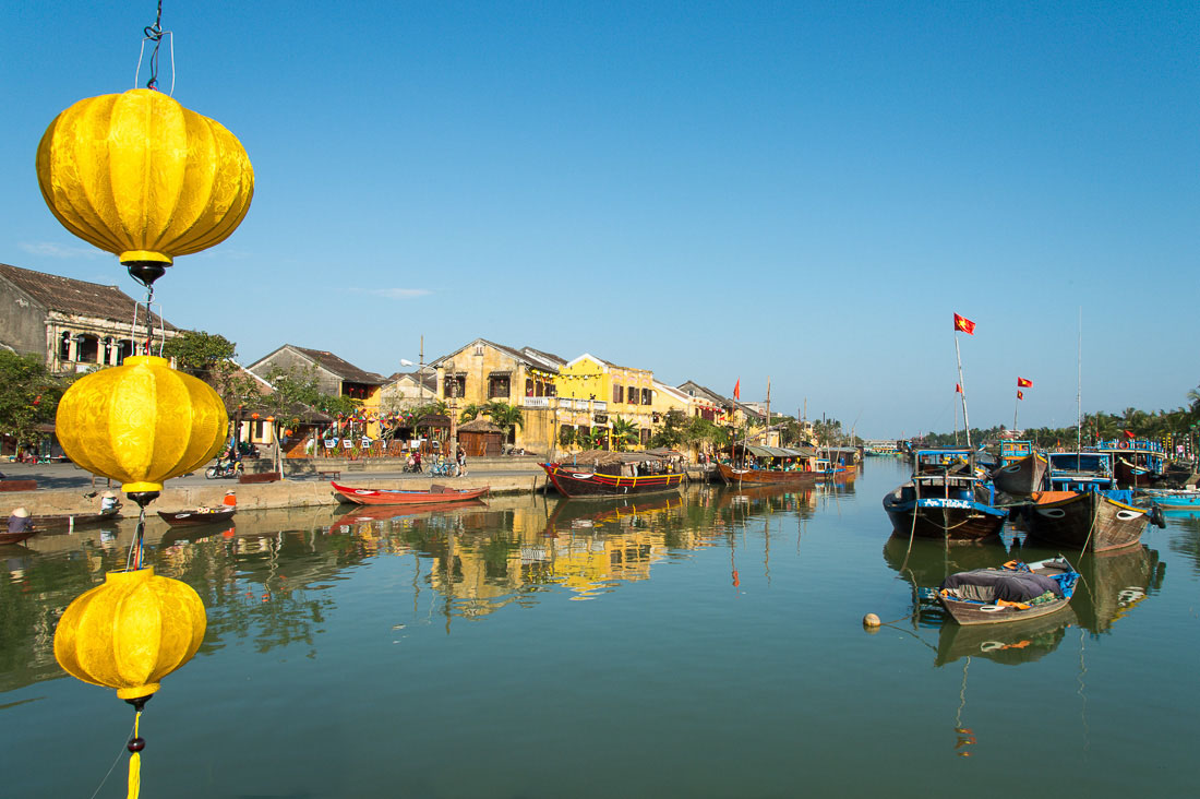 Traditional fishing boats and view of the old town, Thu Bon river, Hoi An, Quang Nam province. Viet Nam, Indochina, South east Asia.