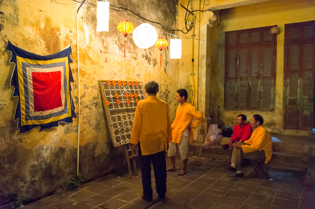 People in traditional costumes playing chess during the full moon festivity. Hoi An, Quang Nam province. Viet Nam, Indochina, South east Asia.