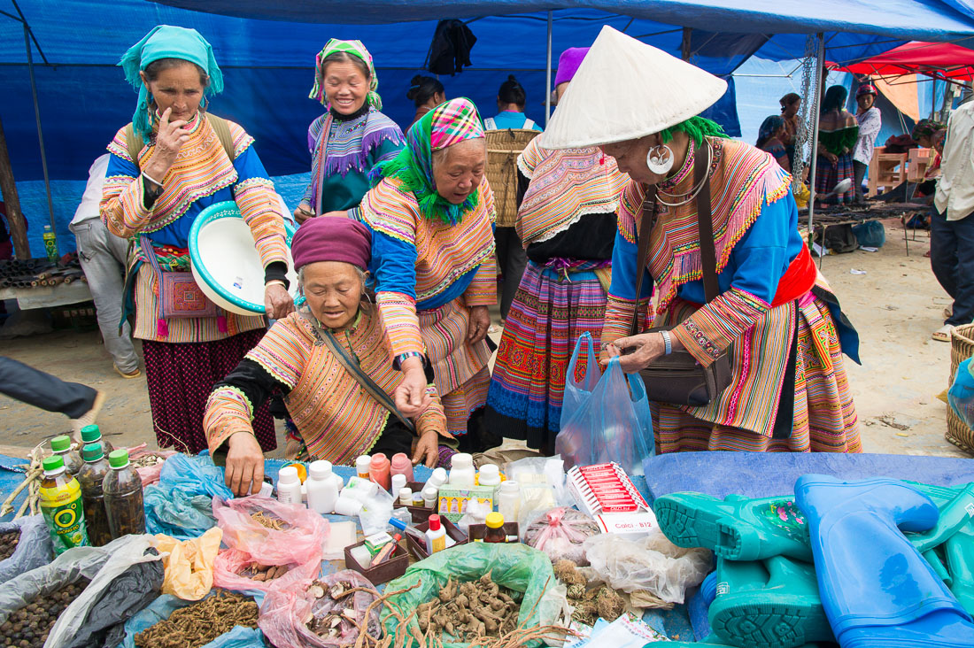 Women from the Flower Hmong people ethnic minority, buying medicines and cosmetics at the busy Bac Ha market, Lao Cai Province, Viet Nam, Indochina, South East Asia.