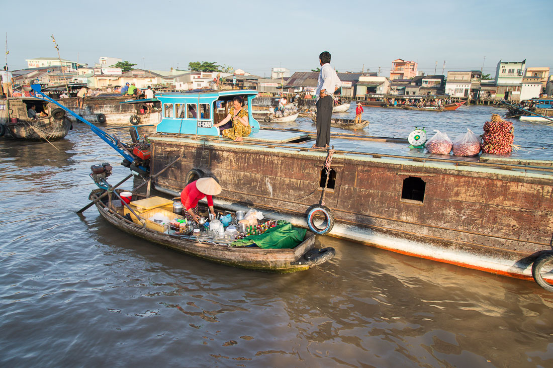 A woman catering breakfast early morning at the Cai Rang vegetable floating market in the Mekong River Delta, Can Tho, Hau Giang Province, Viet Nam, Indochina, South East Asia.