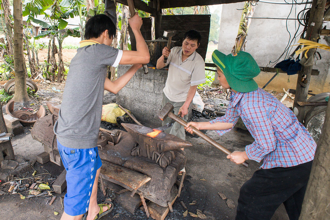 A family of blacksmith at work, producing kives, hatchets, and all sort of cutting devices. Viet Nam, Indochina, South East Asia.