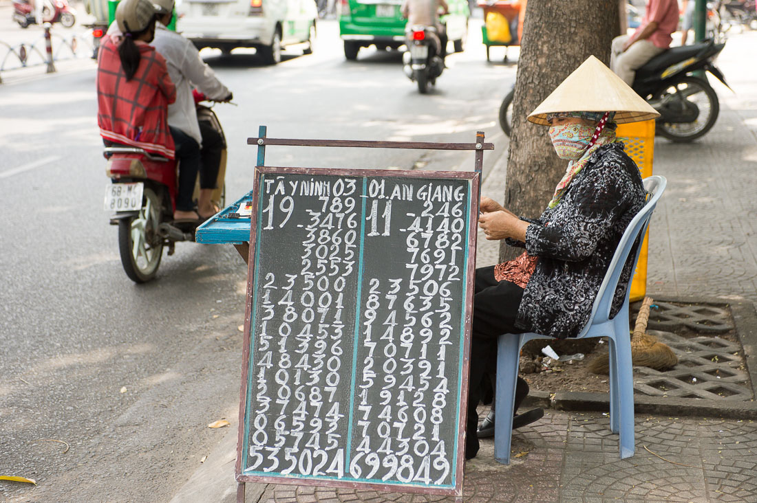 A woman selling lottery tickets in Ho Chi Minh City (Saigon). Viet Nam, Indochina, South East Asia.