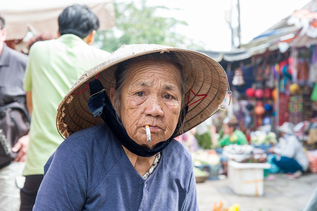 Old Vietnamese woman, smoking a cigarette at Hoi An market, Quang Nam province, Viet Nam, Indochina, South East Asia.