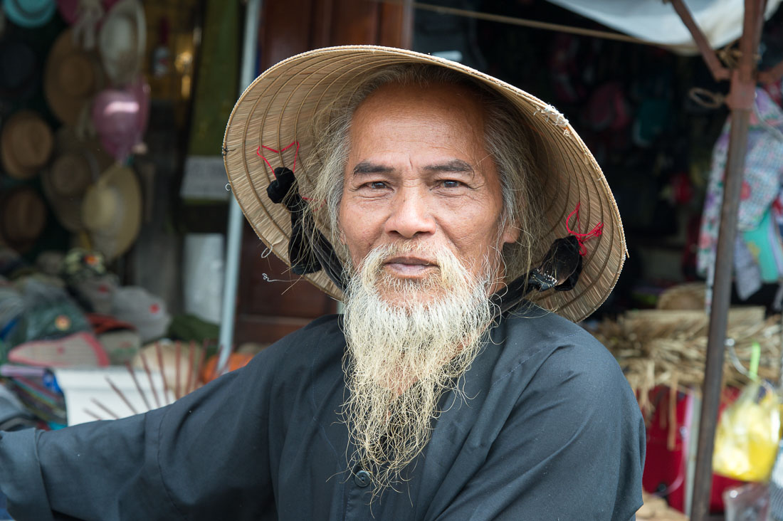 Old man at the Hoi An market very proud of his long white beard. Quang Nam Province, Viet Nam, Indochina, South East Asia.