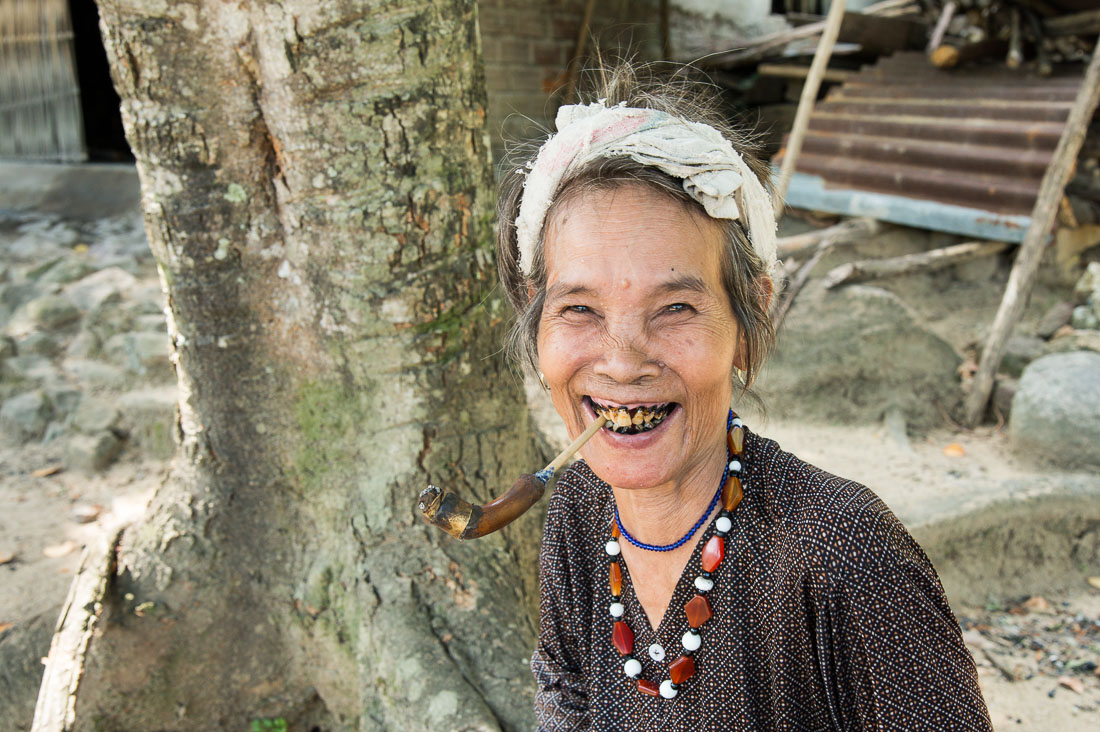 An old woman from the mountains in the Quang Nam Province, with her black stained teeth because of the addiction of chewing paan (lime, tobacco, areca nuts and betel leaves). Viet Nam, Indochina, South East Asia