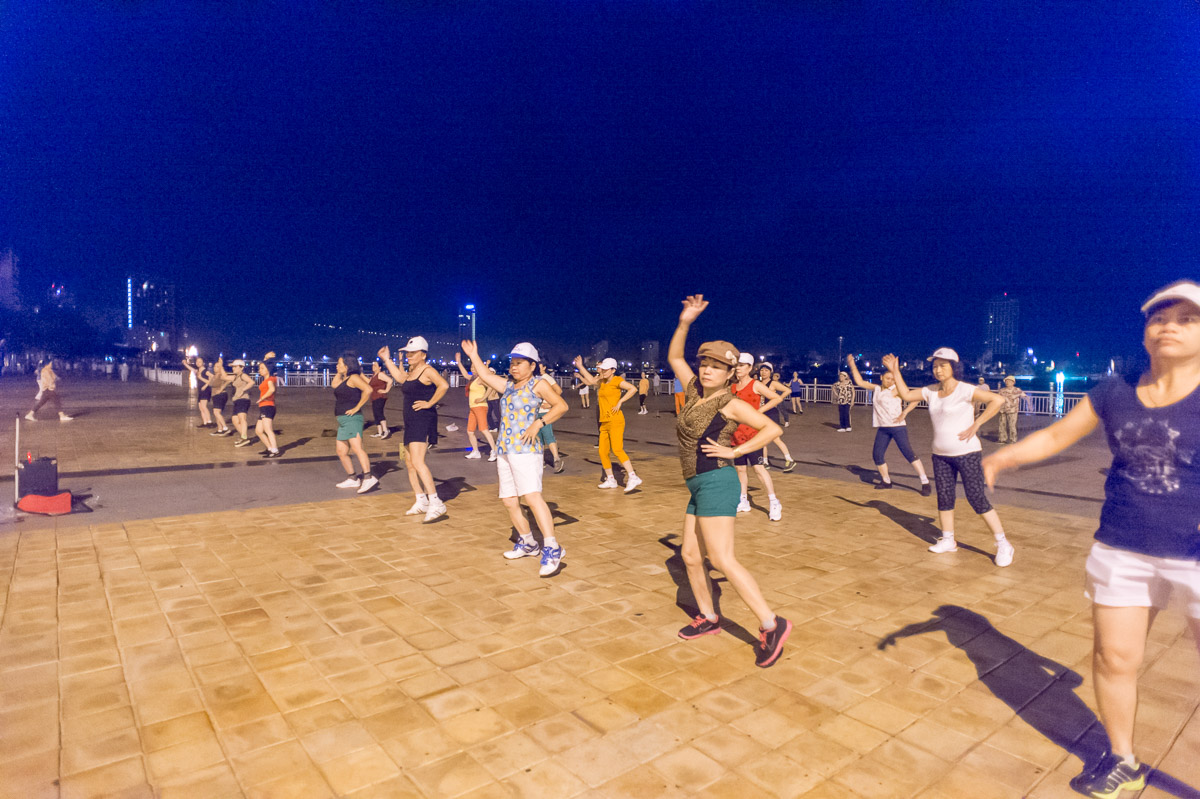 Healthy Vietnamese women practicing aerobic exercise just before sunrise, on the banks of Han River. Da Nang Viet Nam, Indochina, South East Asia. Nikon D4, 20mm f2.8