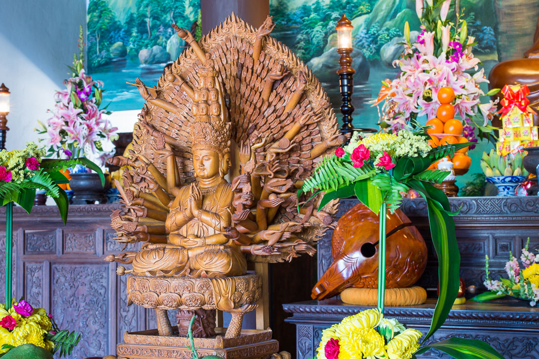 Wood carved Buddhist statue of Asura, a deity with three faces and many arms at To Dinh Van Duc pagoda, Hoi An, Quang Nam province, Viet Nam, Indochina, South East Asia