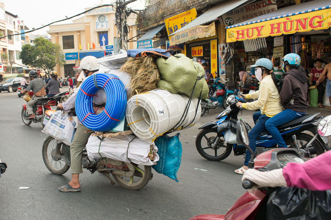 A delivery man with his motorbike really fully loaded of any sort of merchandise. Ho Chi Minh City (Saigon), Viet Nam, Indochina, South East Asia.