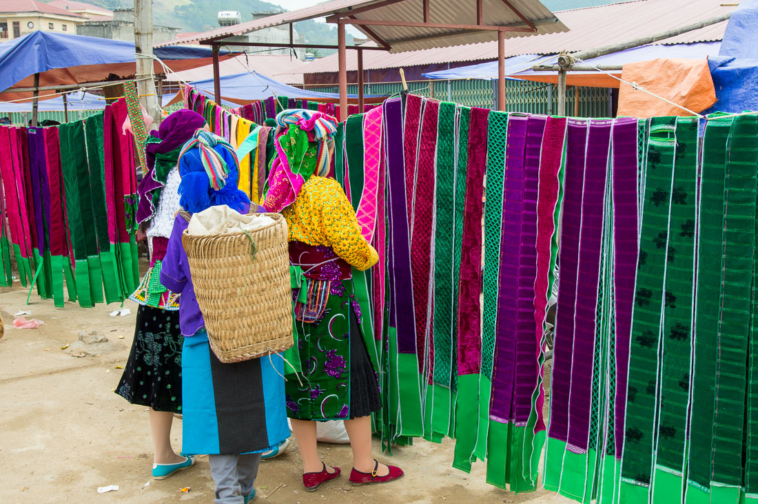 Women from the Black Hmong people ethnic minority at the Don Van market buying traditional clothes. Ha Giang Province, Viet Nam, Indochina, South East Asia