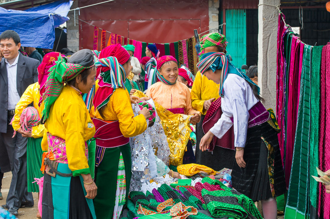 Women from the Black Hmong people ethnic minority group, buying traditional clothes at busy market in Dong Van, Ha Giang Province, Viet Nam, Indochina, South East Asia