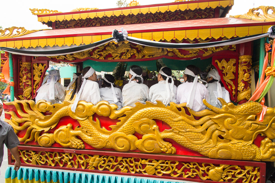 Family members sitting inside the hearse, during a traditional Vietnamese funeral. Hoi An, Quang Nam province, Viet Nam, Indochina, South East Asia.