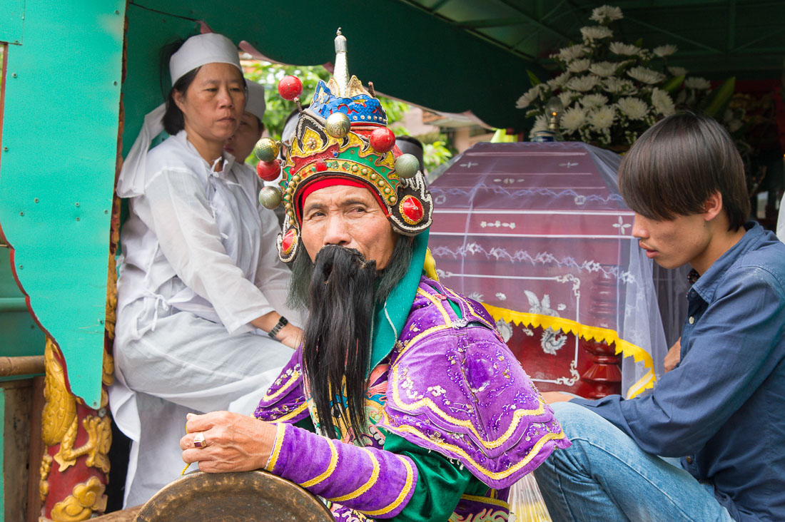 Family members and the master of ceremony sitting inside the hearse, during a traditional Vietnamese funeral. Hoi An, Quang Nam province, Viet Nam, Indochina, South East Asia.